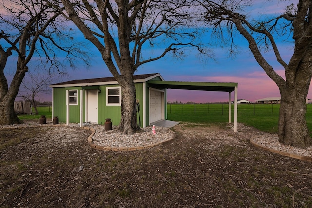 view of front of house featuring fence, a carport, an outdoor structure, a front lawn, and a garage