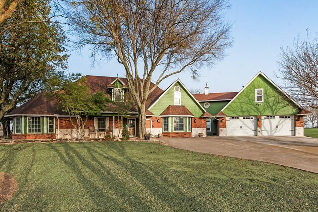 view of front of property with a garage, driveway, brick siding, and a front lawn