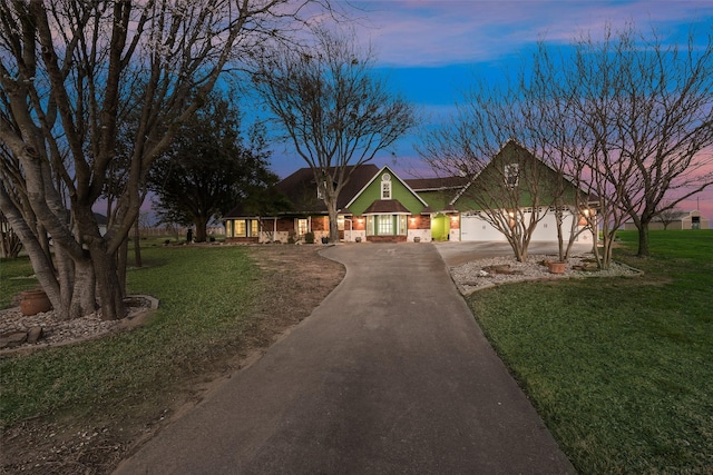 view of front of house featuring driveway, an attached garage, and a front lawn