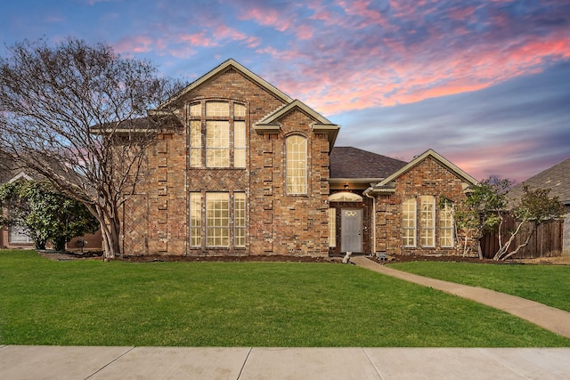 view of front of home featuring brick siding and a front yard