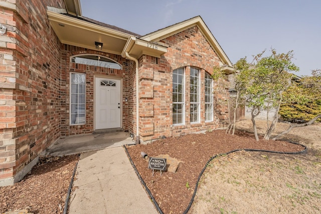 view of exterior entry with brick siding