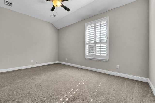 empty room with vaulted ceiling, visible vents, baseboards, and carpet floors