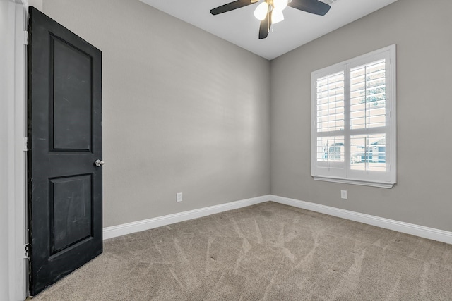 empty room with ceiling fan, baseboards, and carpet