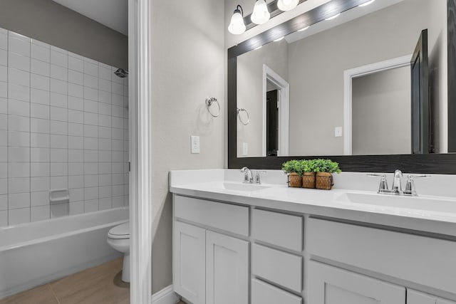 full bathroom with double vanity, toilet, shower / bathing tub combination, and a sink