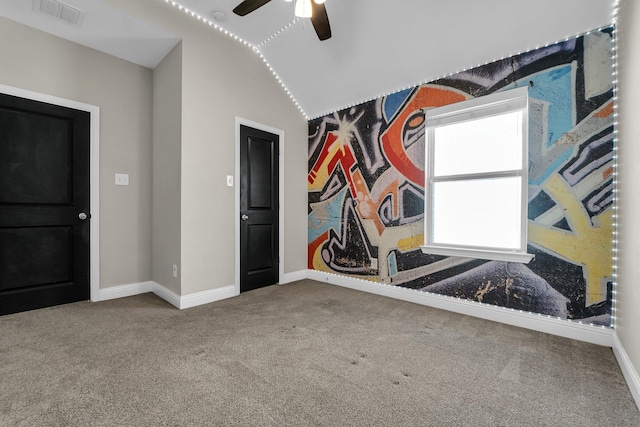 carpeted empty room with baseboards, visible vents, and ceiling fan