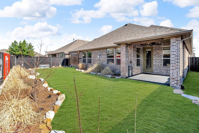 back of property featuring a fenced backyard, brick siding, and a lawn