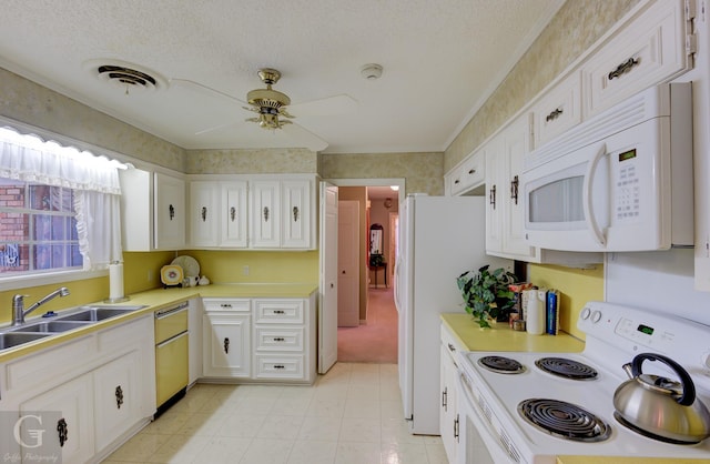 kitchen featuring visible vents, white appliances, white cabinetry, and light countertops