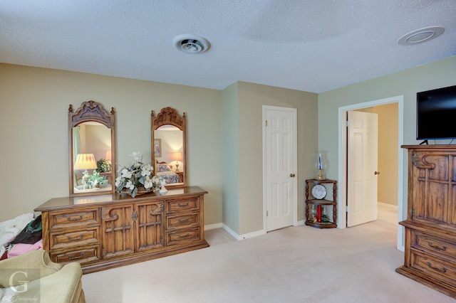 sitting room featuring visible vents, light carpet, a textured ceiling, and baseboards