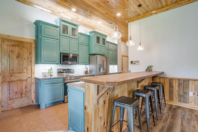 399 Brindley Rd, Maypearl, TX 76064 - kitchen featuring wooden ceiling, a breakfast bar, wainscoting, decorative backsplash, and stainless steel appliances