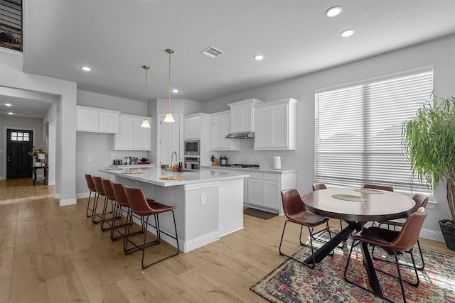 kitchen with stainless steel appliances, light wood-type flooring, visible vents, and white cabinetry