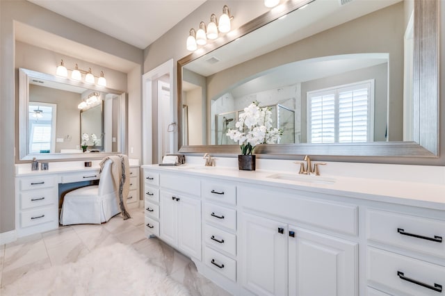 bathroom featuring a stall shower, marble finish floor, a healthy amount of sunlight, and a sink