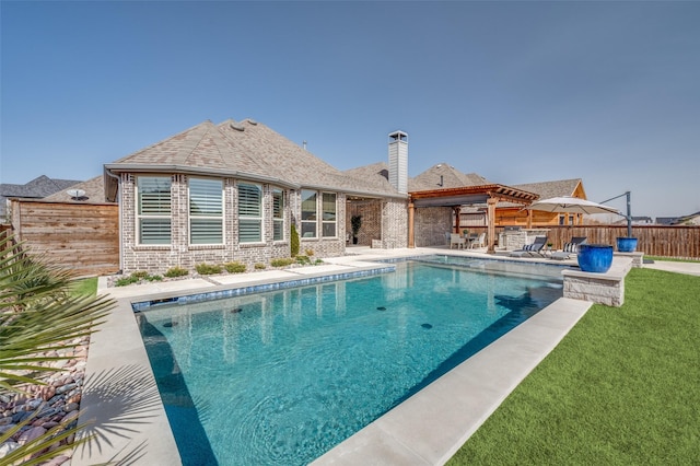 view of swimming pool featuring a fenced in pool, a patio area, a fenced backyard, and a lawn