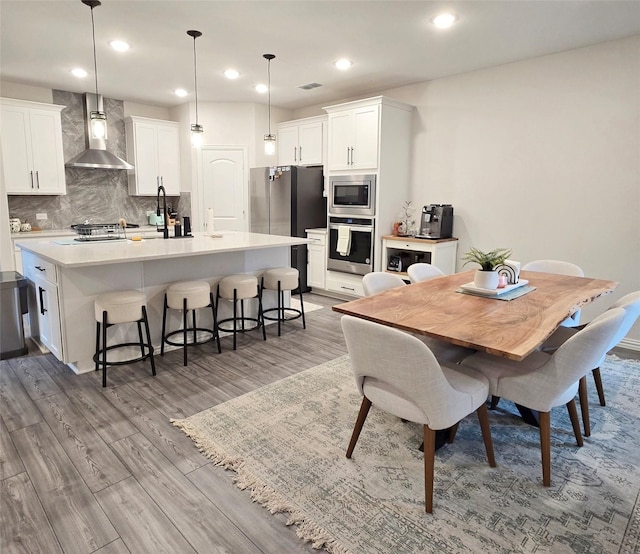 dining area with wood finished floors, visible vents, and recessed lighting