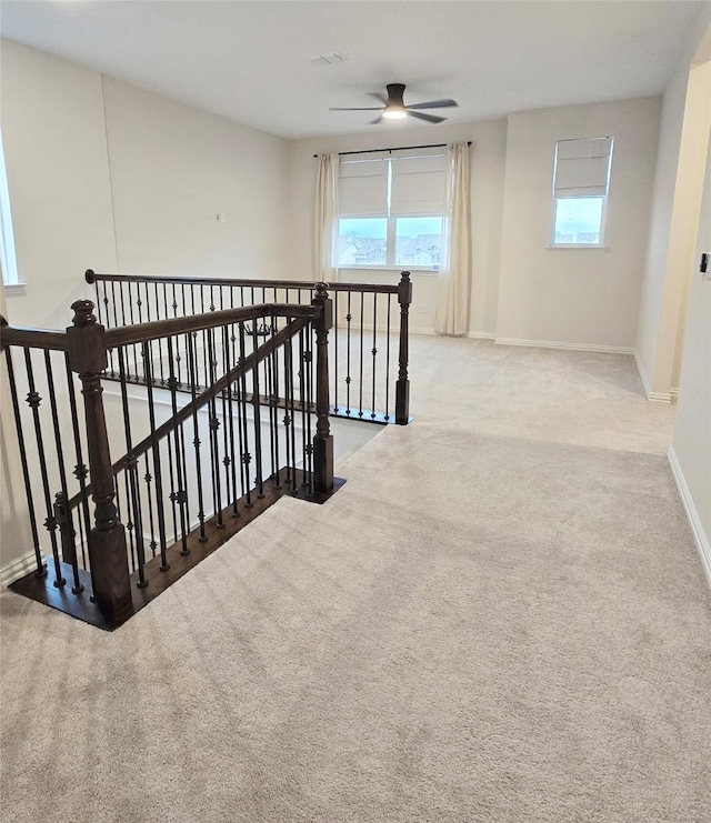 corridor with carpet, an upstairs landing, and baseboards