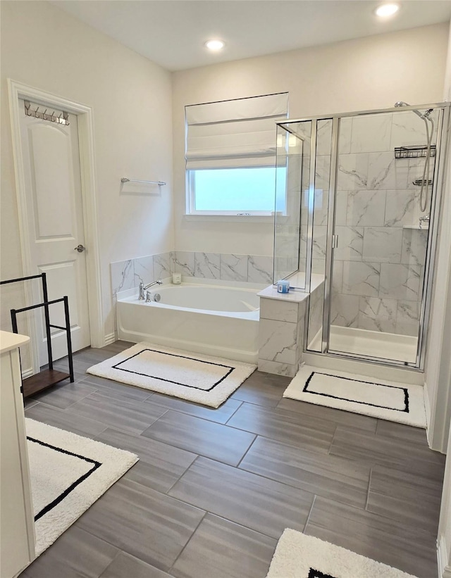 full bathroom featuring recessed lighting, a garden tub, vanity, and a shower stall