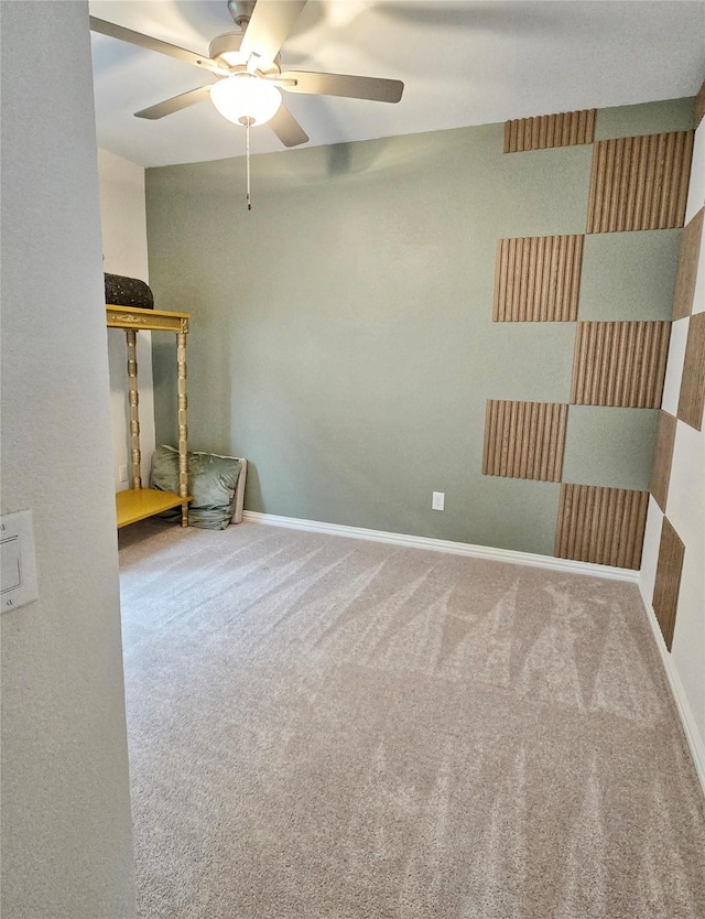 carpeted empty room featuring ceiling fan and baseboards