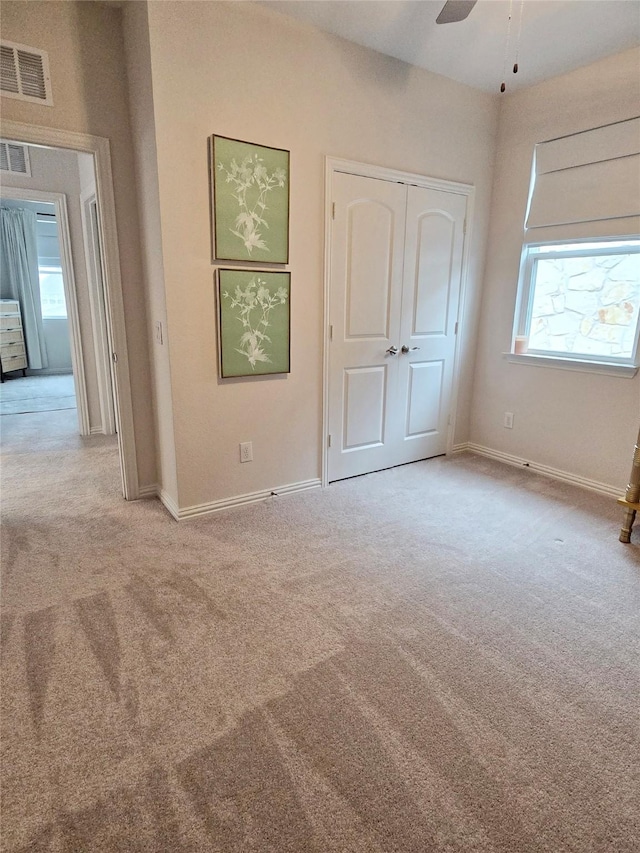 unfurnished bedroom featuring carpet floors, a closet, visible vents, and baseboards