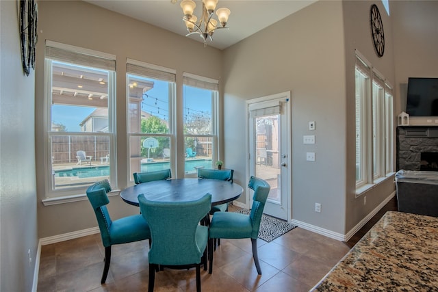 dining area with dark tile patterned floors, a notable chandelier, and baseboards