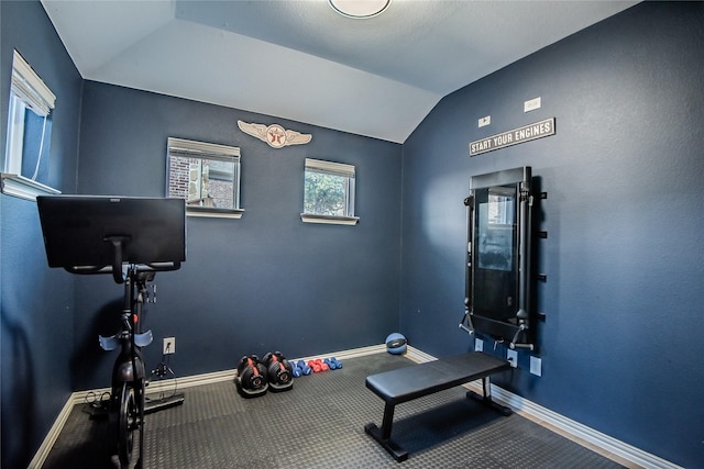 workout area featuring lofted ceiling and baseboards