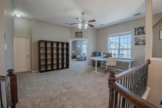 carpeted office space with visible vents, a ceiling fan, and baseboards