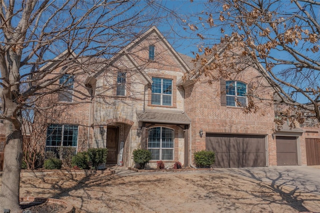 view of front of house featuring brick siding, roof with shingles, concrete driveway, and an attached garage