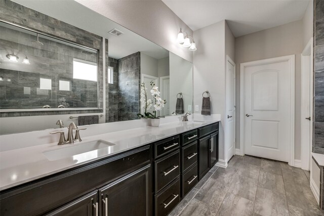 1121 Ash St, Celina, TX 75009 - full bathroom featuring double vanity, visible vents, a sink, and tiled shower