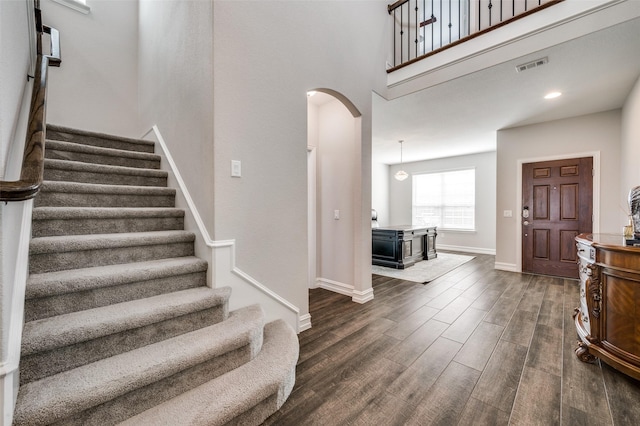 1121 Ash St, Celina, TX 75009 - foyer entrance with arched walkways, visible vents, baseboards, stairs, and dark wood-style floors