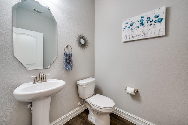 1121 Ash St, Celina, TX 75009 - half bath with a textured wall, toilet, wood finished floors, visible vents, and baseboards