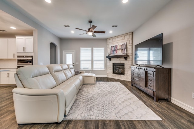 1121 Ash St, Celina, TX 75009 - living room featuring arched walkways, dark wood-style flooring, a fireplace, recessed lighting, and visible vents