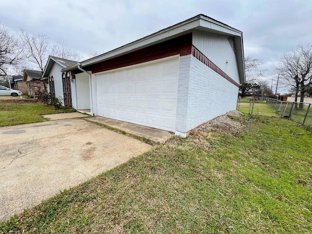 garage featuring driveway and fence