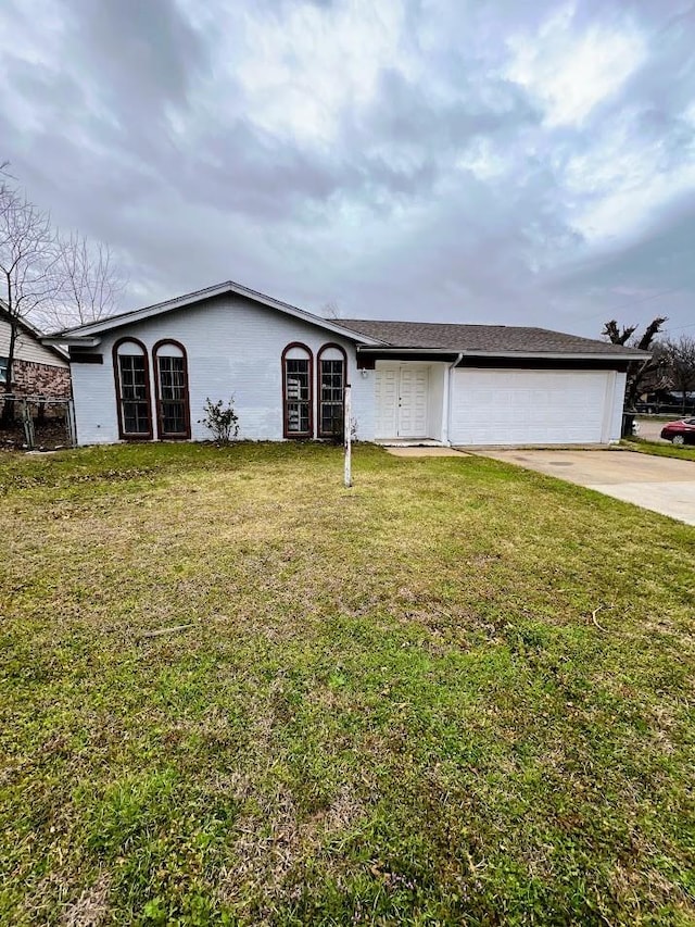 ranch-style home with concrete driveway, an attached garage, and a front lawn