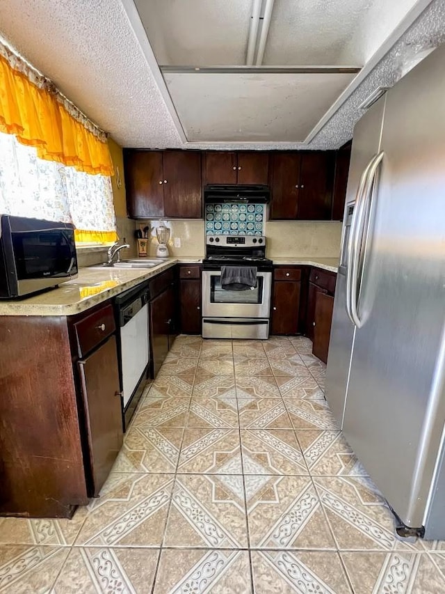 kitchen featuring light tile patterned floors, stainless steel appliances, light countertops, a sink, and under cabinet range hood