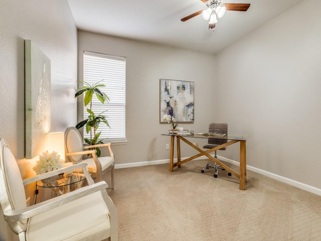 carpeted office with a ceiling fan and baseboards