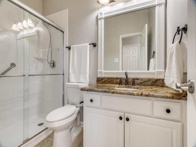 full bath with a stall shower, vanity, and toilet