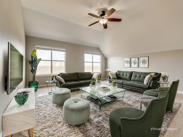 living area featuring lofted ceiling, ceiling fan, wood finished floors, and baseboards