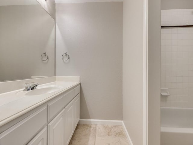 full bath featuring vanity and baseboards