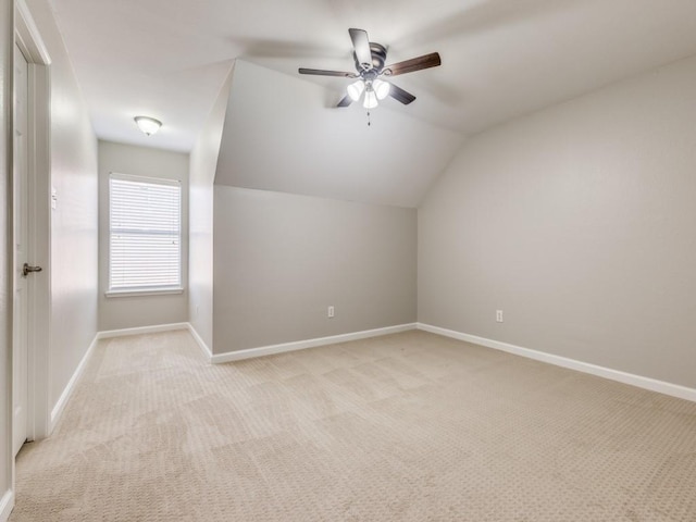 additional living space featuring vaulted ceiling, ceiling fan, baseboards, and light colored carpet