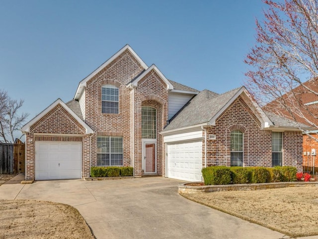 traditional-style home featuring driveway, brick siding, an attached garage, and a shingled roof