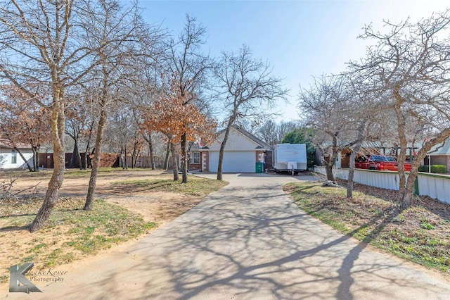 view of front of home featuring a garage, fence, and an outbuilding