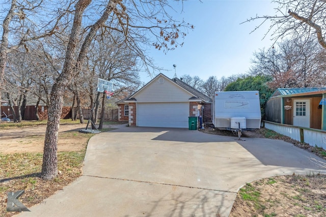 view of property exterior featuring a garage, an outbuilding, brick siding, and fence