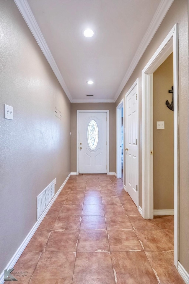 entrance foyer with baseboards, light tile patterned floors, visible vents, and crown molding