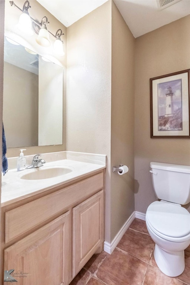 bathroom featuring tile patterned flooring, toilet, visible vents, vanity, and baseboards