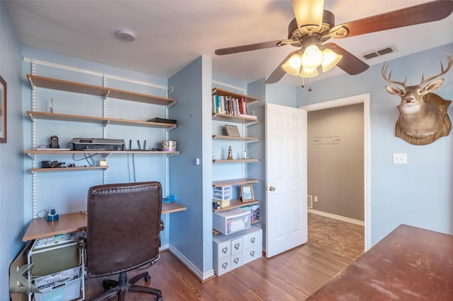 office space with visible vents, ceiling fan, baseboards, and wood finished floors