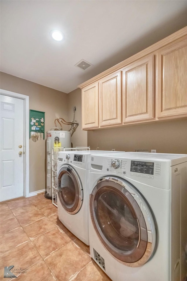 washroom featuring light tile patterned floors, cabinet space, visible vents, water heater, and separate washer and dryer