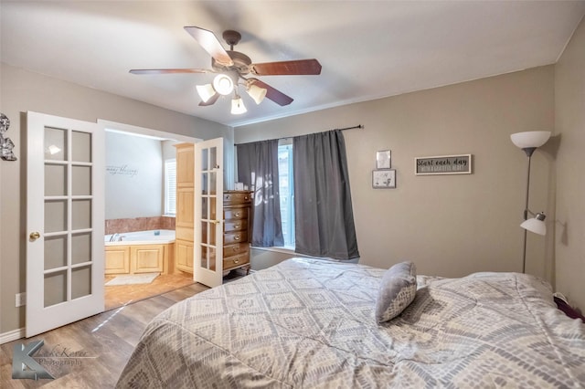 bedroom featuring connected bathroom, light wood-type flooring, and ceiling fan