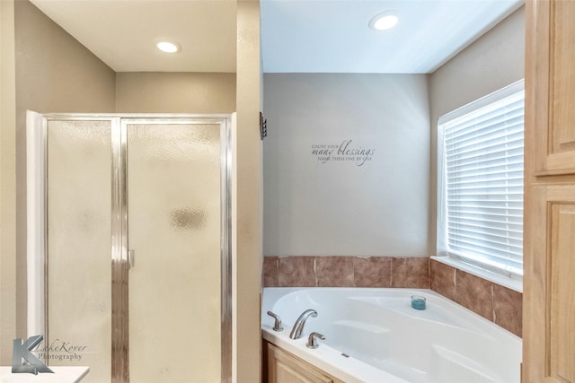 bathroom with recessed lighting, a healthy amount of sunlight, a shower stall, and a bath