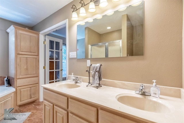 full bathroom with double vanity, tile patterned floors, a sink, and a shower stall