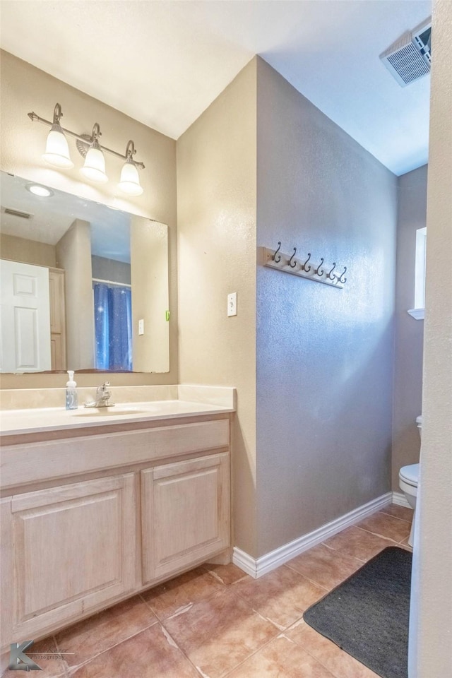 full bath featuring visible vents, toilet, vanity, baseboards, and tile patterned floors