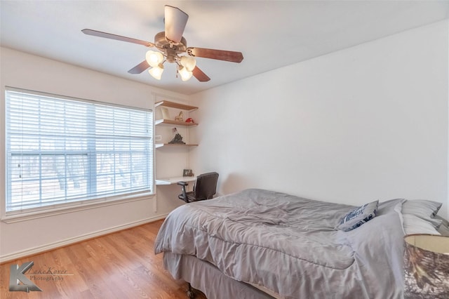 bedroom with baseboards, a ceiling fan, and wood finished floors