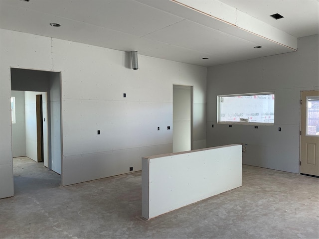 kitchen with unfinished concrete flooring and white cabinetry